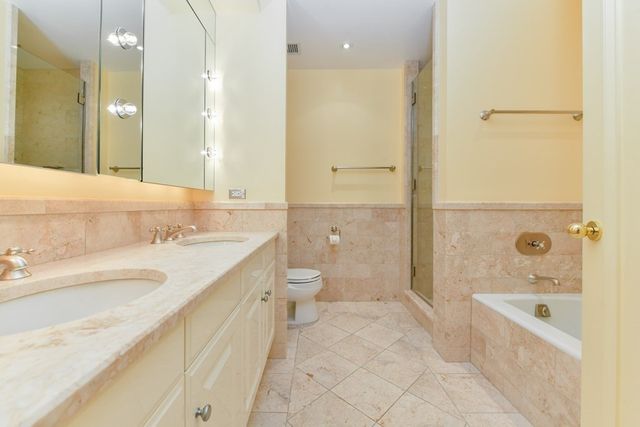 a spacious bathroom with a granite countertop sink a toilet and shower