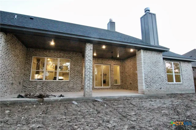 a view of a brick house with floor to ceiling windows