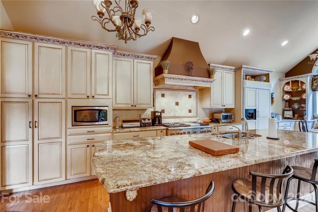 5508 Griffith Road Monroe, NC 28112 - Photo 18 of 48 a kitchen with stainless steel appliances granite countertop a sink dishwasher and cabinets with wooden floor