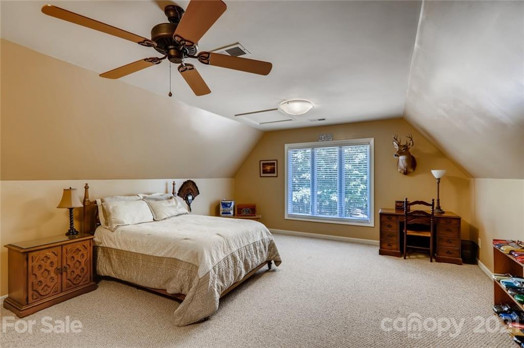 5508 Griffith Road Monroe, NC 28112 - Photo 29 of 48 a bedroom with a bed a chandelier and a couch