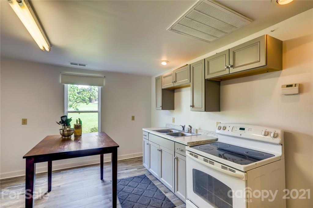 5508 Griffith Road Monroe, NC 28112 - Photo 44 of 48 a kitchen with stainless steel appliances a stove a sink cabinets and a window
