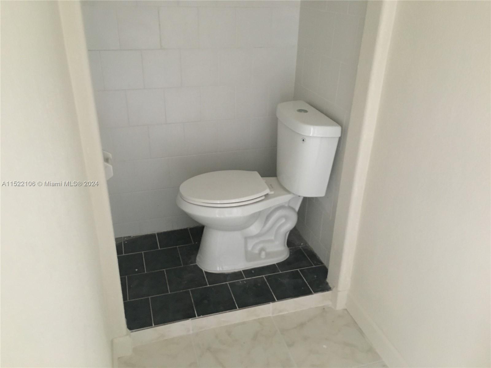 6737 Azalea Drive Miramar, FL 33023 - Photo 12 of 18 a white toilet sitting in a bathroom
