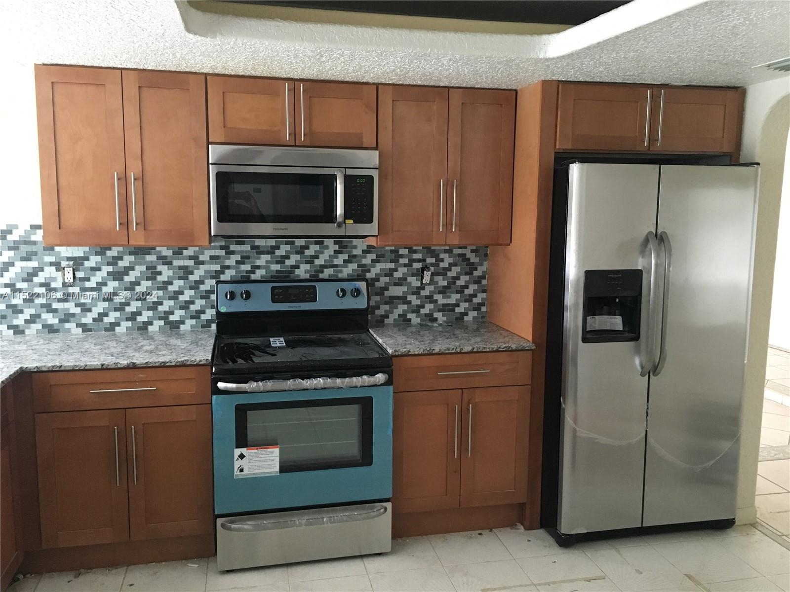 6737 Azalea Drive Miramar, FL 33023 - Photo 3 of 18 a kitchen with stainless steel appliances granite countertop a stove a refrigerator and a sink