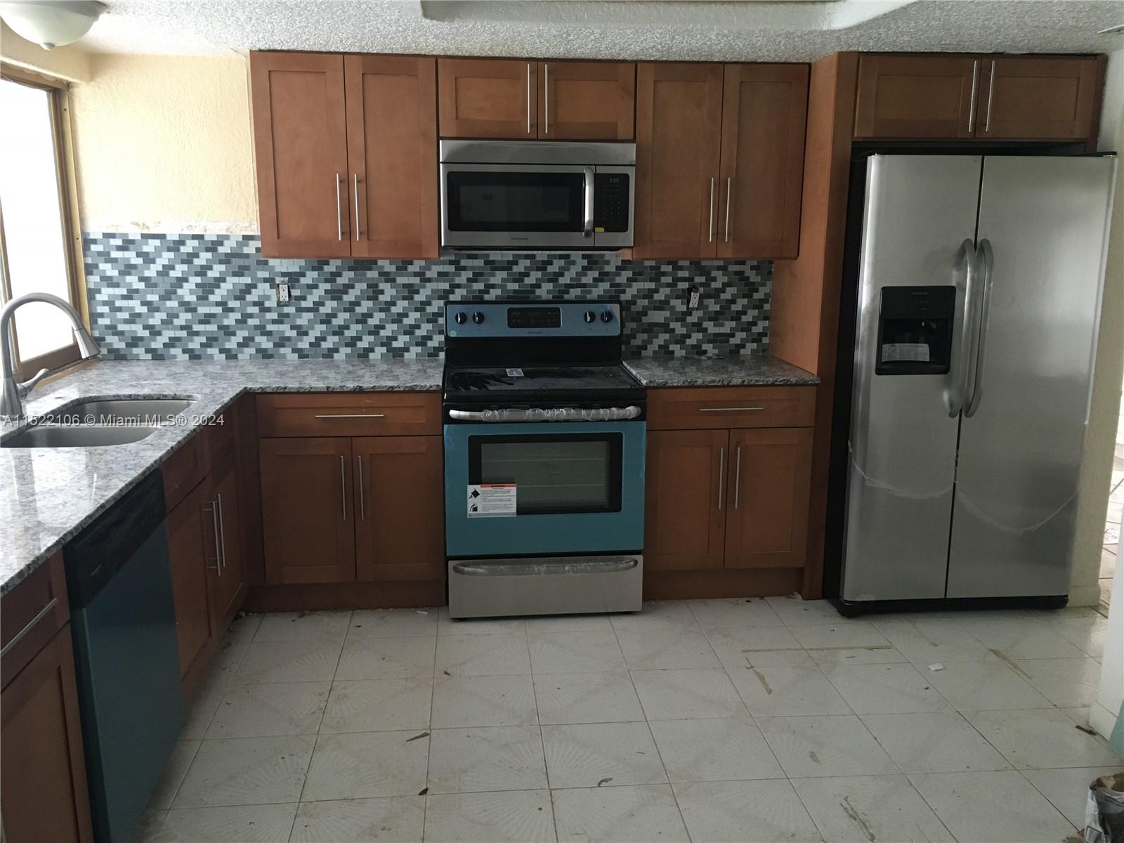 6737 Azalea Drive Miramar, FL 33023 - Photo 4 of 18 a kitchen with stainless steel appliances granite countertop a stove a refrigerator and a sink