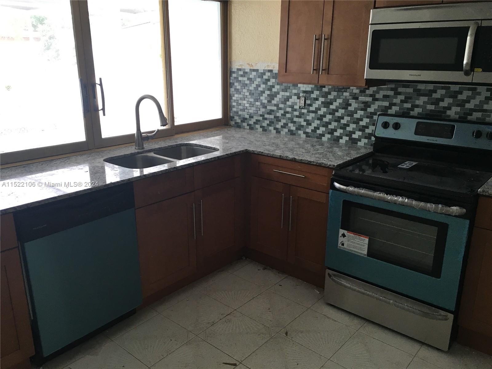 6737 Azalea Drive Miramar, FL 33023 - Photo 5 of 18 a kitchen with granite countertop a stove and a sink