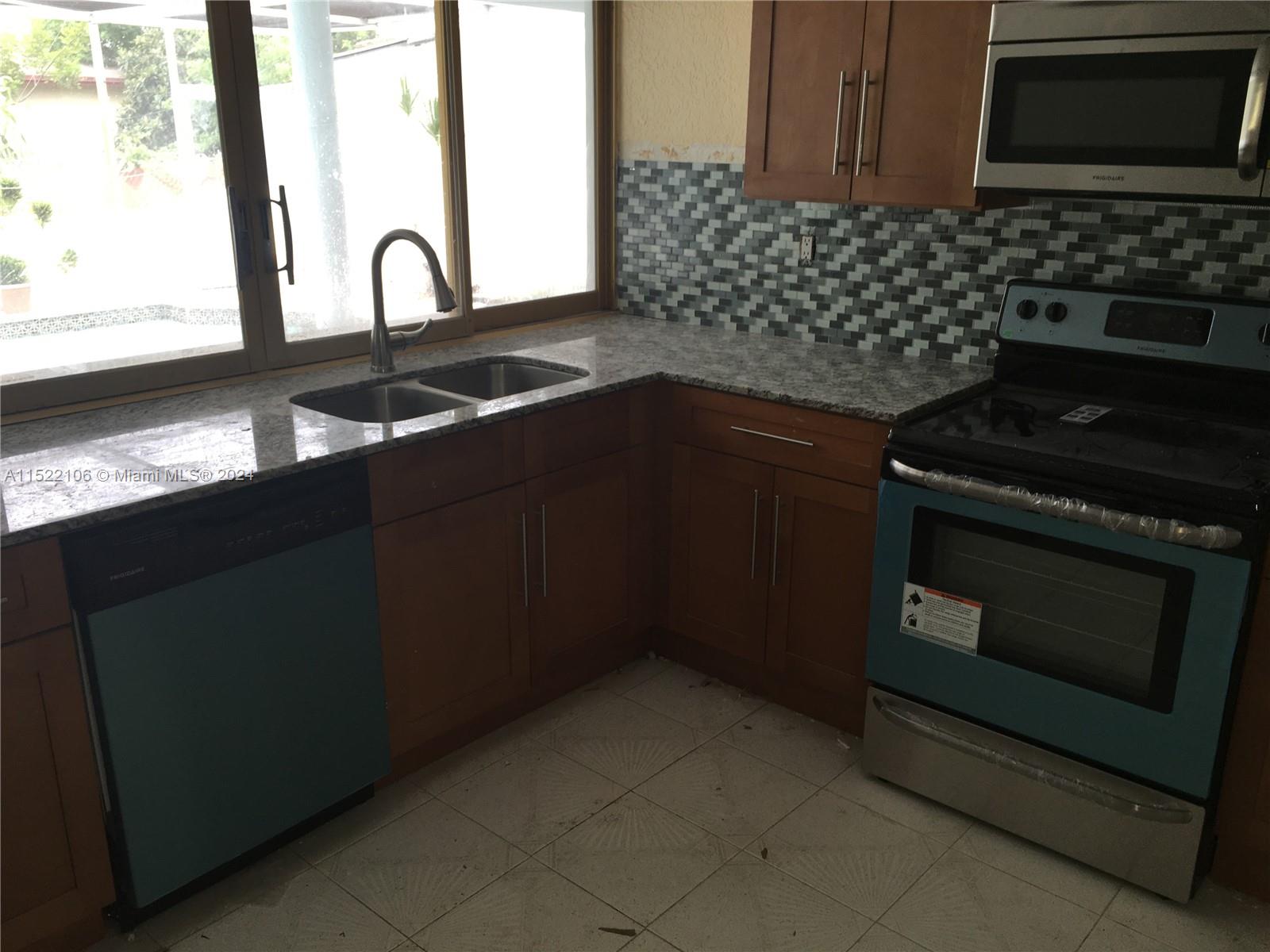 6737 Azalea Drive Miramar, FL 33023 - Photo 6 of 18 a kitchen with granite countertop a stove and a sink