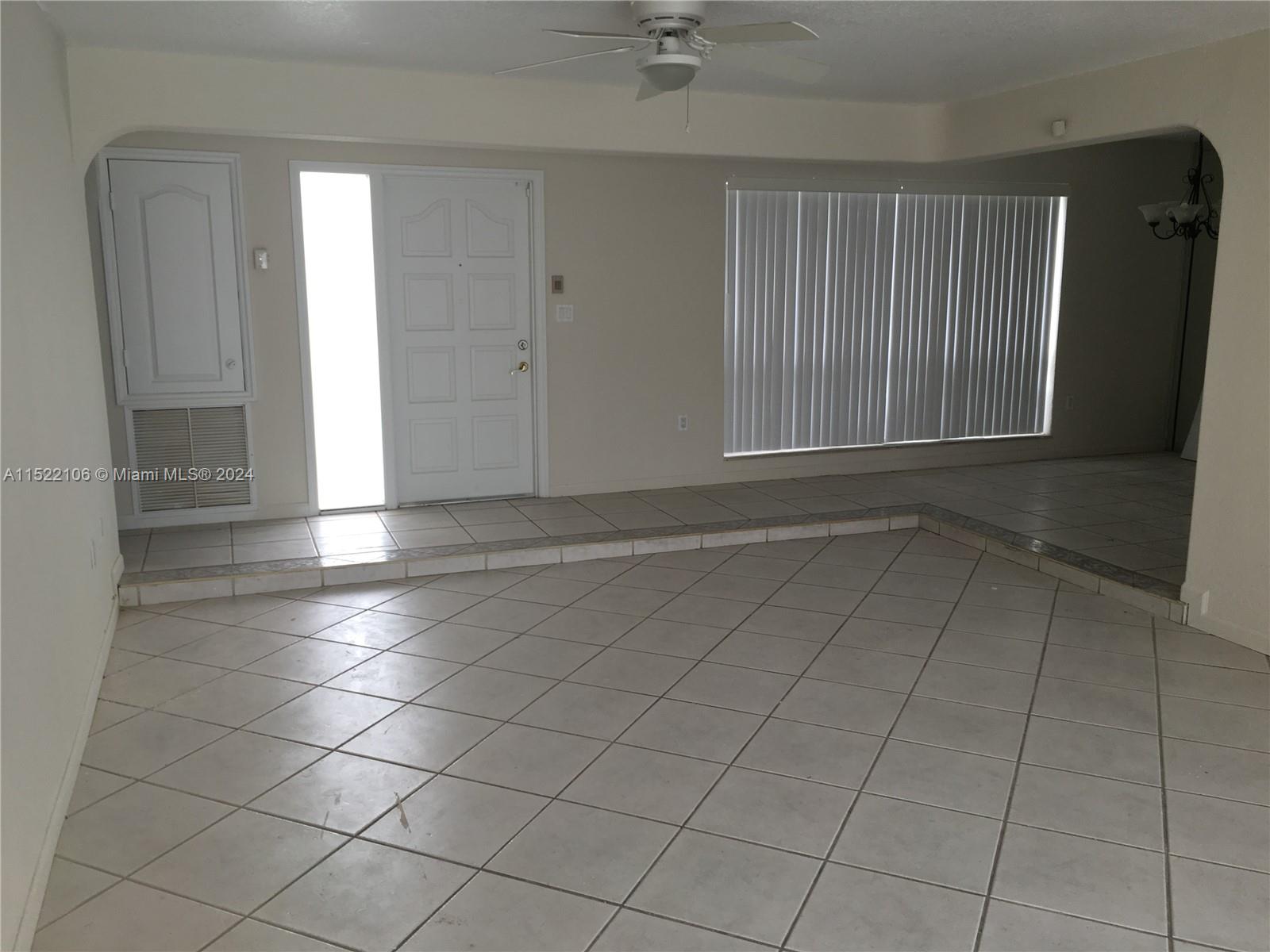 6737 Azalea Drive Miramar, FL 33023 - Photo 8 of 18 an empty room with a fireplace and windows