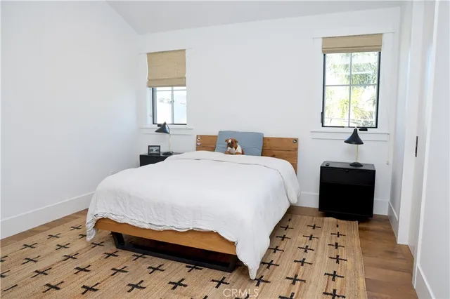 a bedroom with a bed and wooden floor