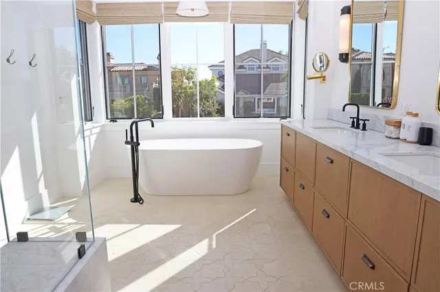 a spacious bathroom with a tub sink and mirror