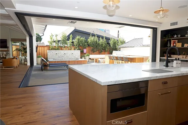 a living room with stainless steel appliances granite countertop a stove and a view of living room