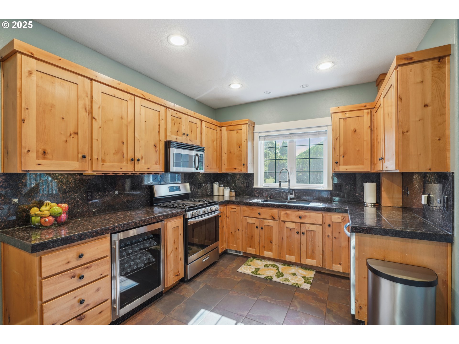303 Maple Street Ridgefield, WA 98642 - Photo 11 of 36 a kitchen with stainless steel appliances granite countertop a stove a sink dishwasher and a microwave