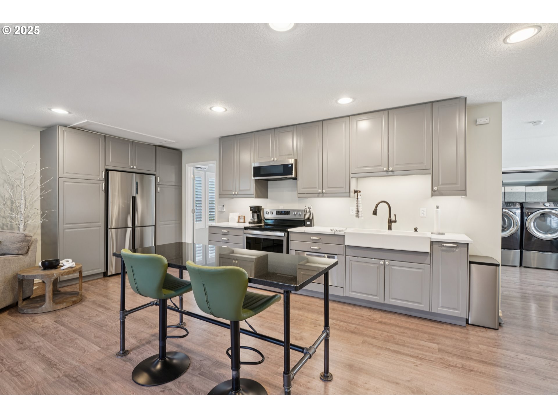 303 Maple Street Ridgefield, WA 98642 - Photo 31 of 36 a kitchen with granite countertop a table chairs microwave and cabinets