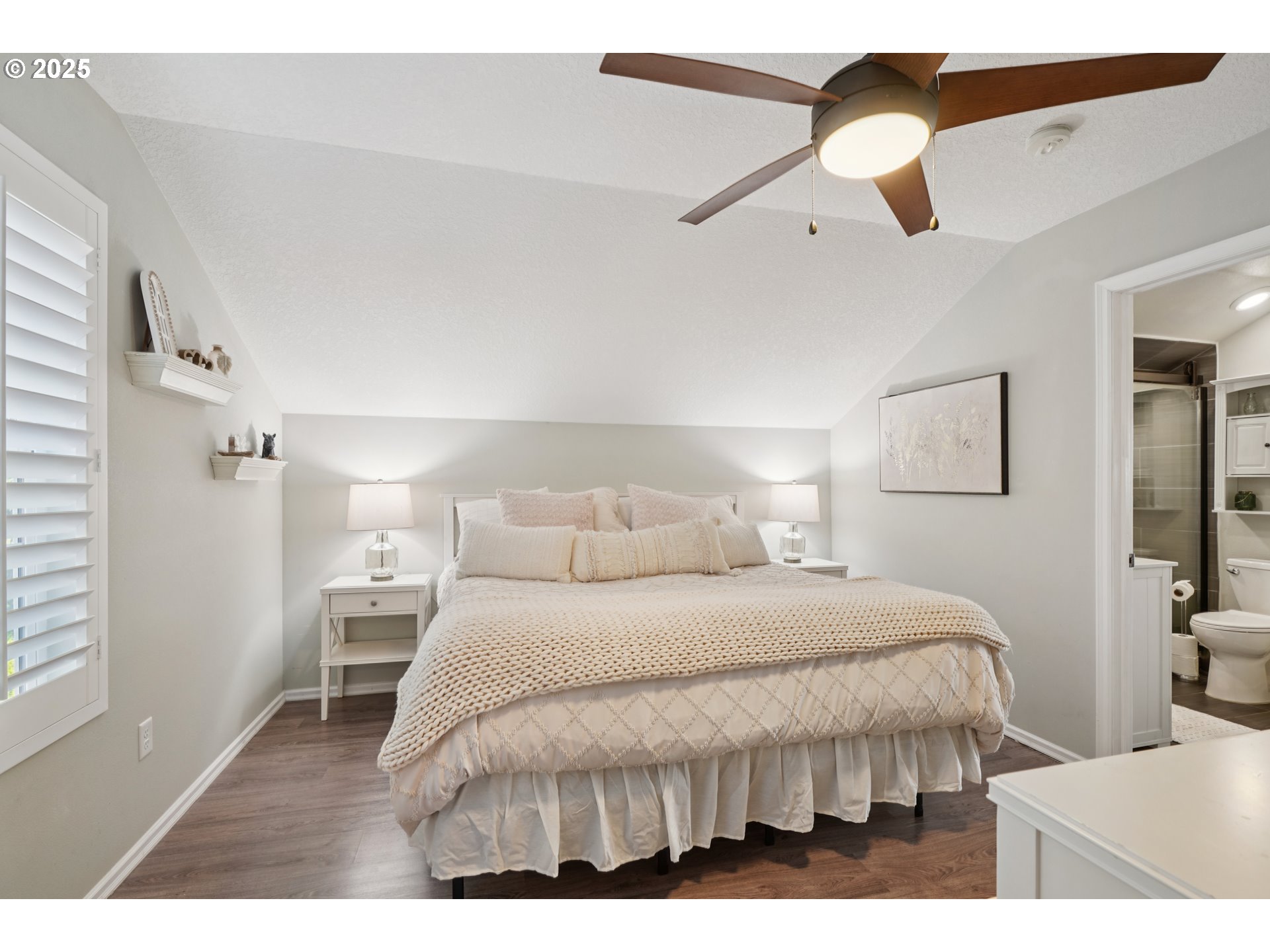 303 Maple Street Ridgefield, WA 98642 - Photo 32 of 36 a bedroom with a bed a chandelier and a painting on the wall