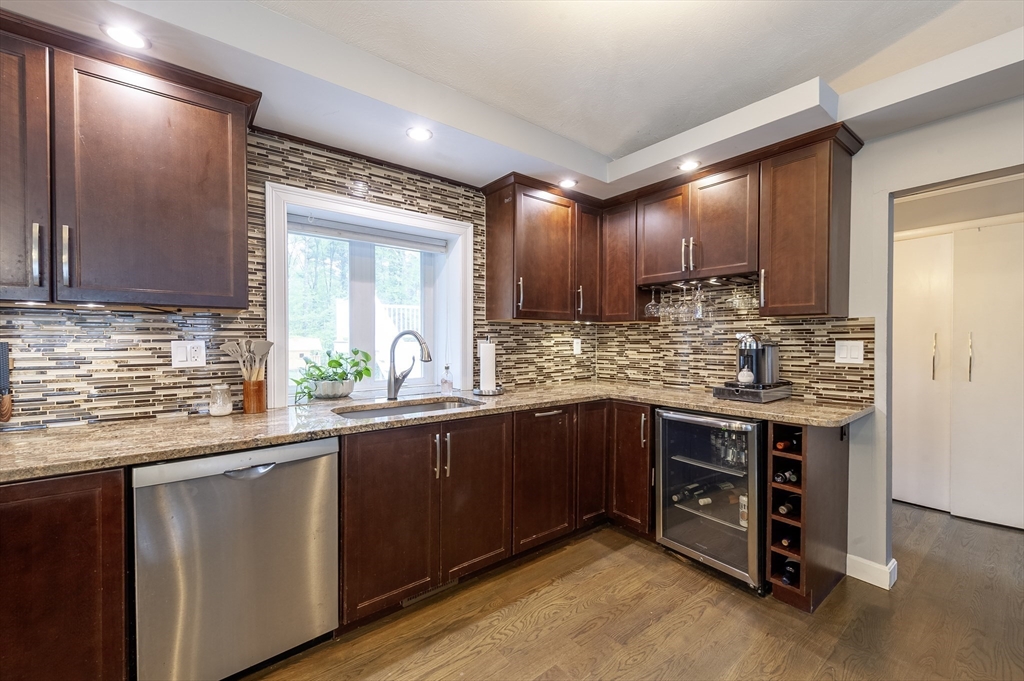 357 Ledge Road Seekonk, MA 02771 - Photo 11 of 42 a kitchen with kitchen island granite countertop a sink cabinets and wooden floor