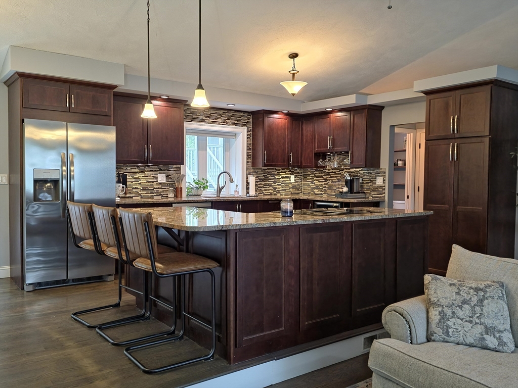 357 Ledge Road Seekonk, MA 02771 - Photo 4 of 42 a kitchen with stainless steel appliances granite countertop a refrigerator a sink a stove a dining table and chairs