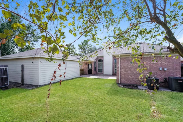 front view of a house with a yard and large trees