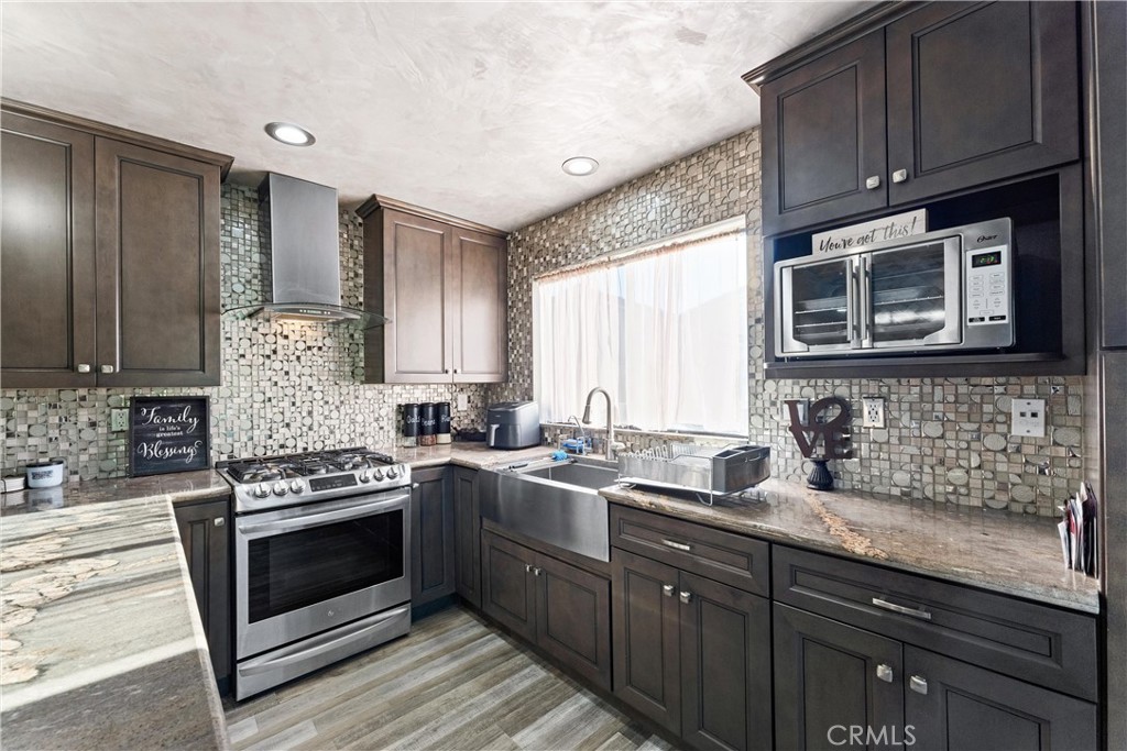 4254 Manx Court Riverside, CA 92503 - Photo 11 of 38 a kitchen with stainless steel appliances a stove sink and cabinets