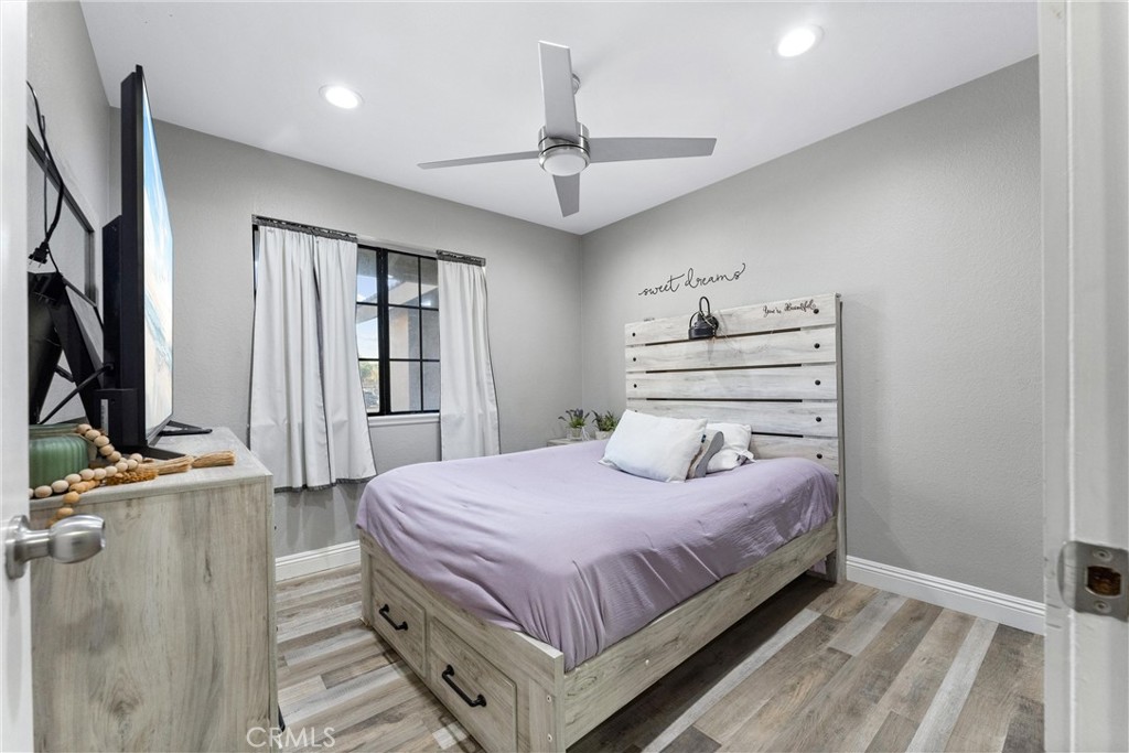 4254 Manx Court Riverside, CA 92503 - Photo 19 of 38 a bedroom with a bed table closet and flat screen tv