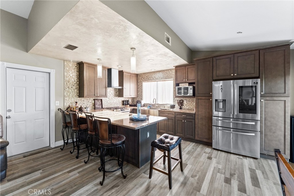 4254 Manx Court Riverside, CA 92503 - Photo 8 of 38 a kitchen with refrigerator cabinets and wooden floor