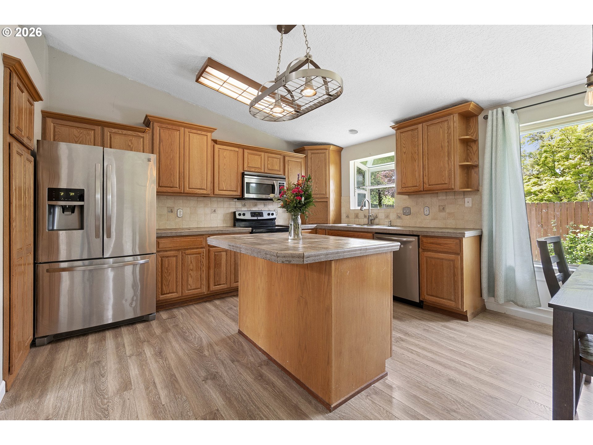 6749 Southwest 174th Place Beaverton, OR 97007 - Photo 11 of 39 a kitchen with stainless steel appliances granite countertop a refrigerator a sink dishwasher a stove with wooden floor and cabinets