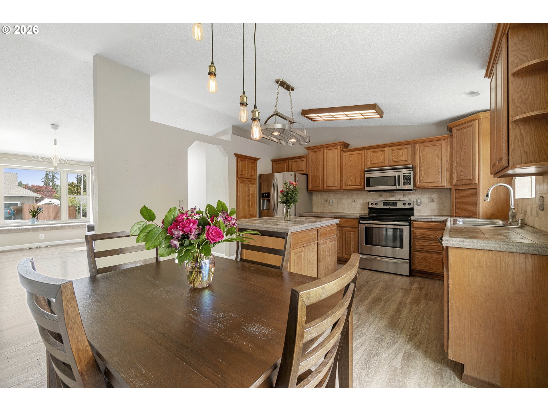 6749 Southwest 174th Place Beaverton, OR 97007 - Photo 16 of 39 a kitchen with stainless steel appliances kitchen island granite countertop a dining table and chairs
