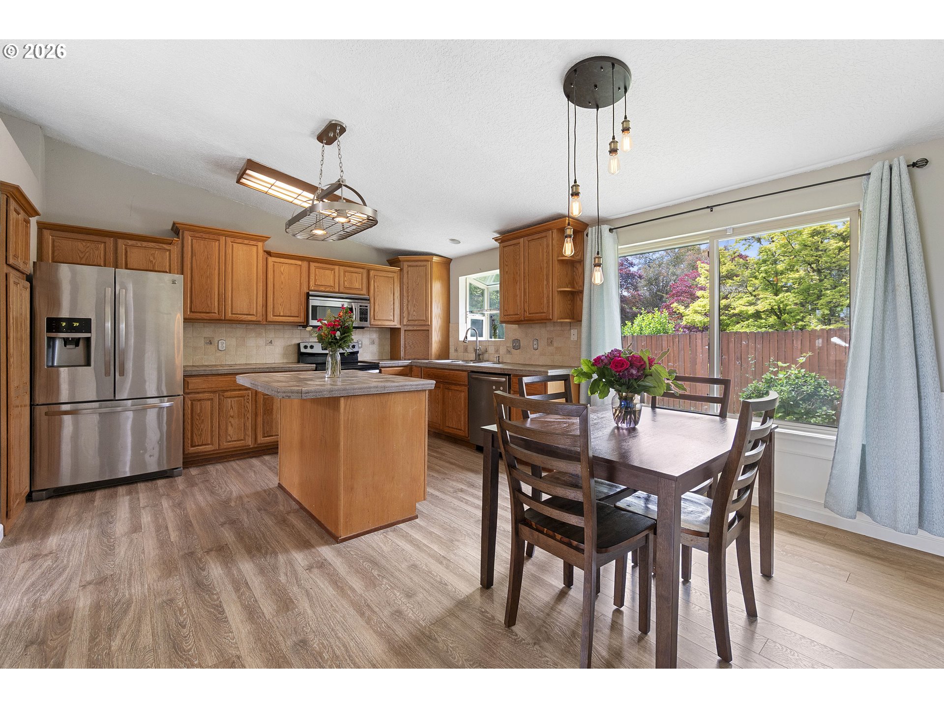 6749 Southwest 174th Place Beaverton, OR 97007 - Photo 9 of 39 a kitchen with stainless steel appliances a dining table chairs and wooden floor