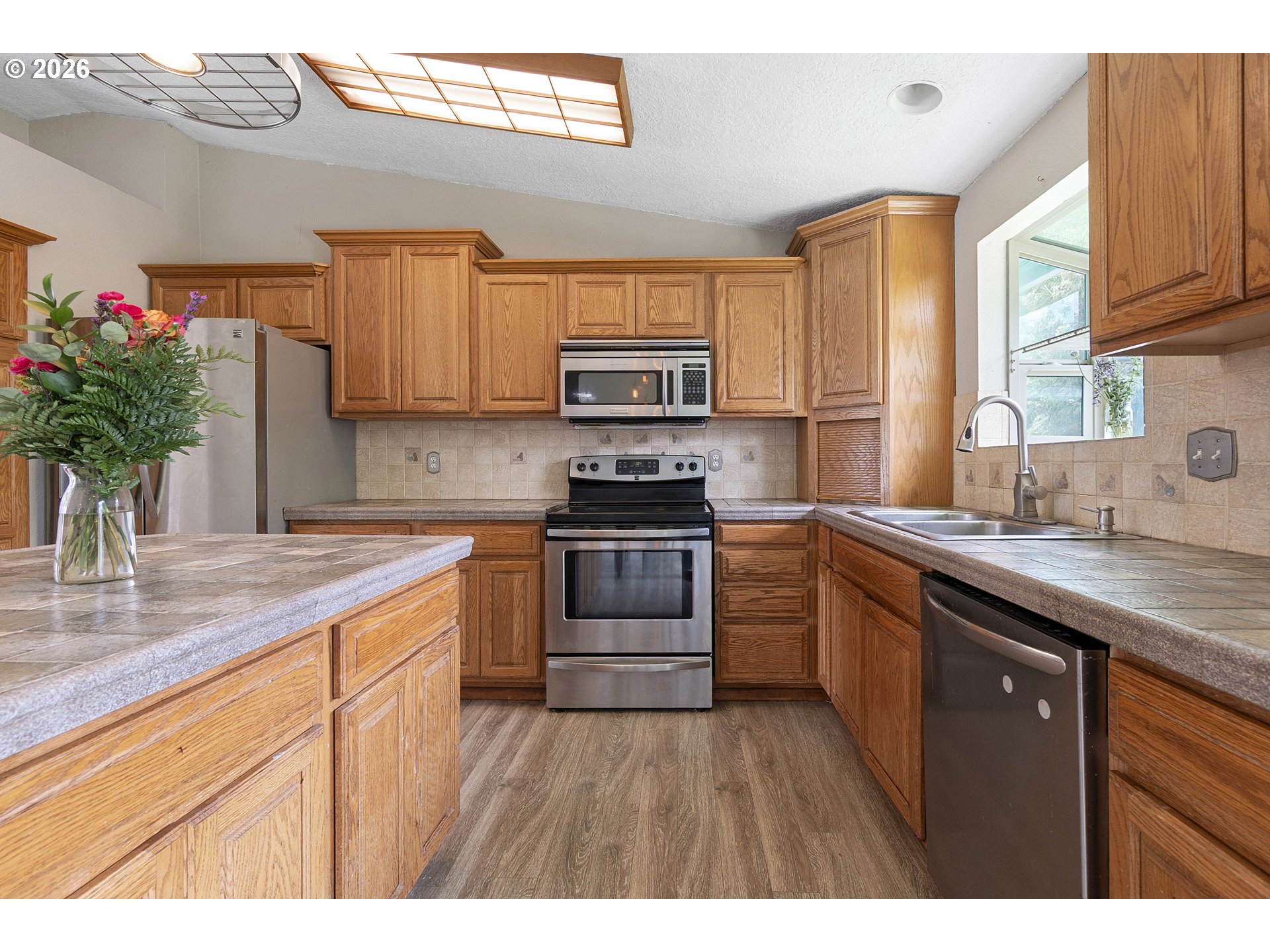 6749 Southwest 174th Place Beaverton, OR 97007 - Photo 10 of 39 a kitchen with a sink stove and cabinets