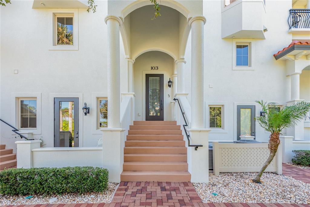 5090 Riverside Drive, Unit 103 Port Orange, FL 32127 - Photo 9 of 62 a front view of a house with a garden