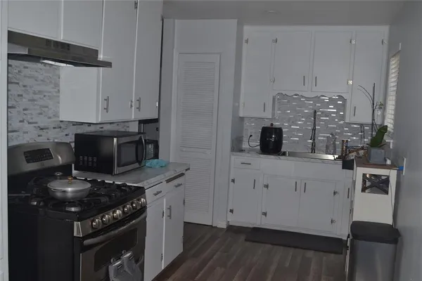 a kitchen with stainless steel appliances a stove a sink and a refrigerator