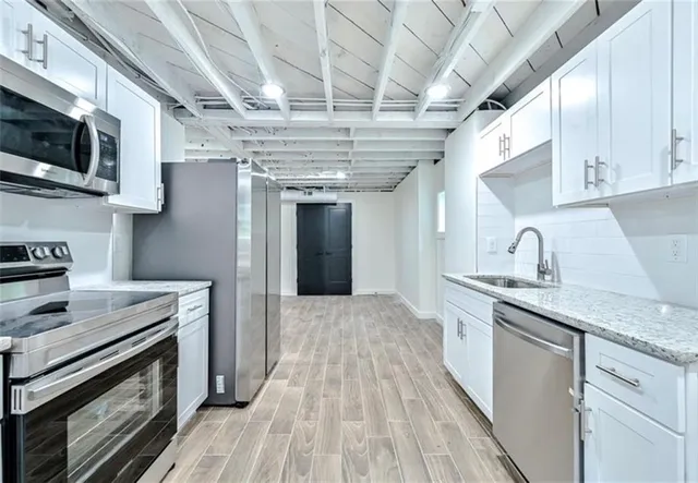 a kitchen with stainless steel appliances granite countertop a sink a stove and cabinets
