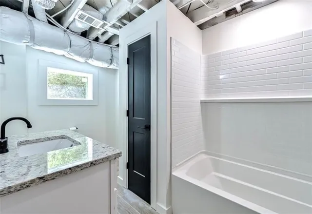 a bath tub sitting next to a bathroom sink