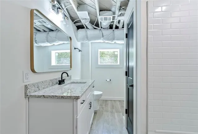 a bathroom with a granite countertop sink a mirror and vanity