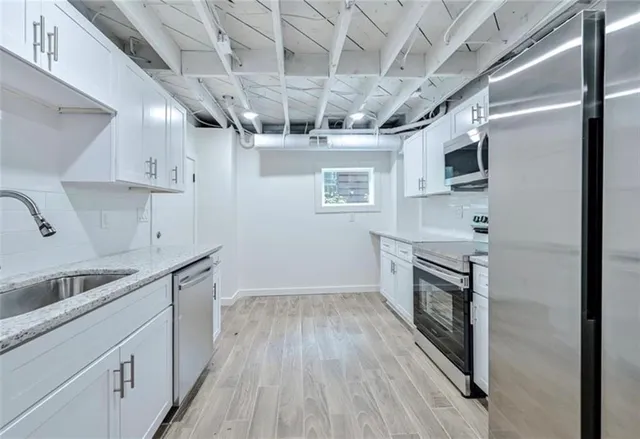 a kitchen with stainless steel appliances granite countertop a sink a stove a refrigerator and cabinets