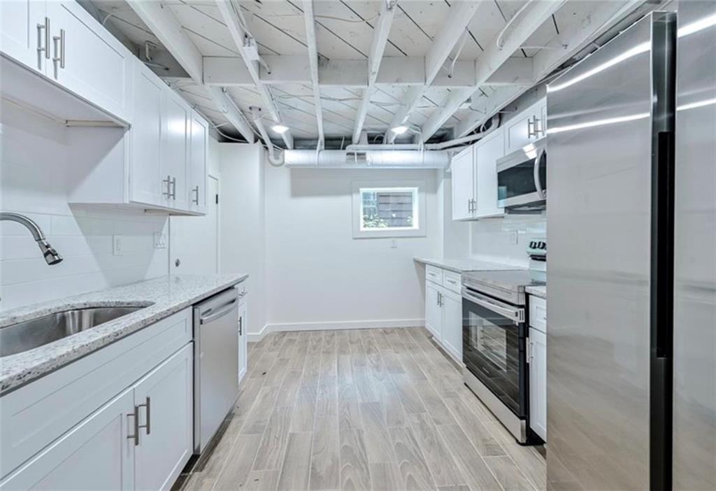 2218 Belvedere Avenue Southwest Atlanta, GA 30311 - Photo 2 of 13 a kitchen with stainless steel appliances granite countertop a sink a stove a refrigerator and cabinets