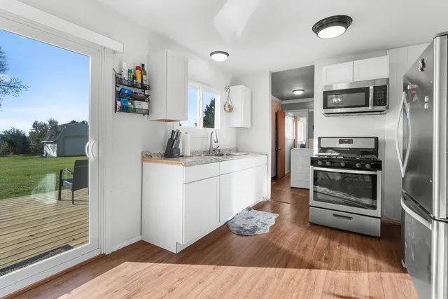 a kitchen with stainless steel appliances kitchen island granite countertop a refrigerator and a stove top oven