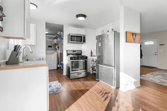 a kitchen with granite countertop a refrigerator stove and sink