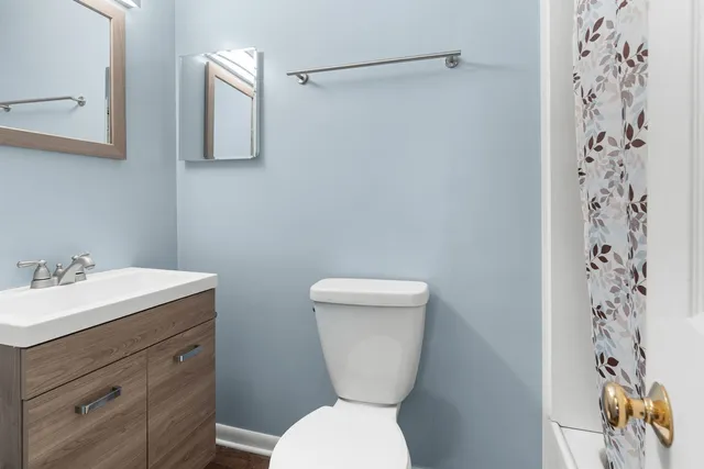 a bathroom with a toilet sink and mirror
