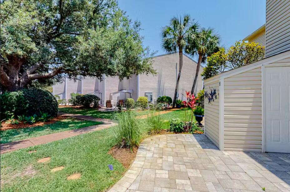 241 Ellis Road, Unit 8 Miramar Beach, FL 32550 - Photo 23 of 29 a view of a backyard with potted plants and large trees
