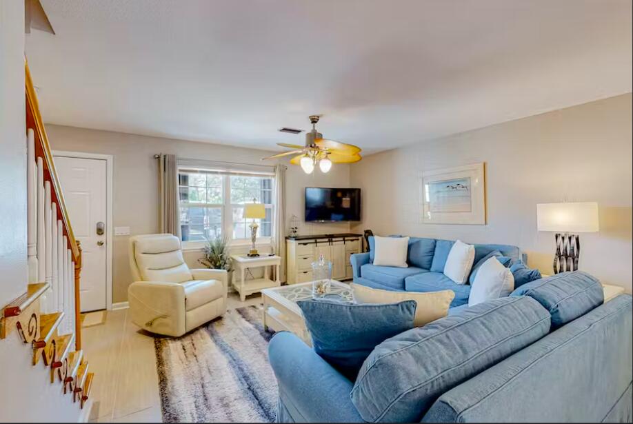 241 Ellis Road, Unit 8 Miramar Beach, FL 32550 - Photo 3 of 29 a living room with furniture a large window and a flat screen tv