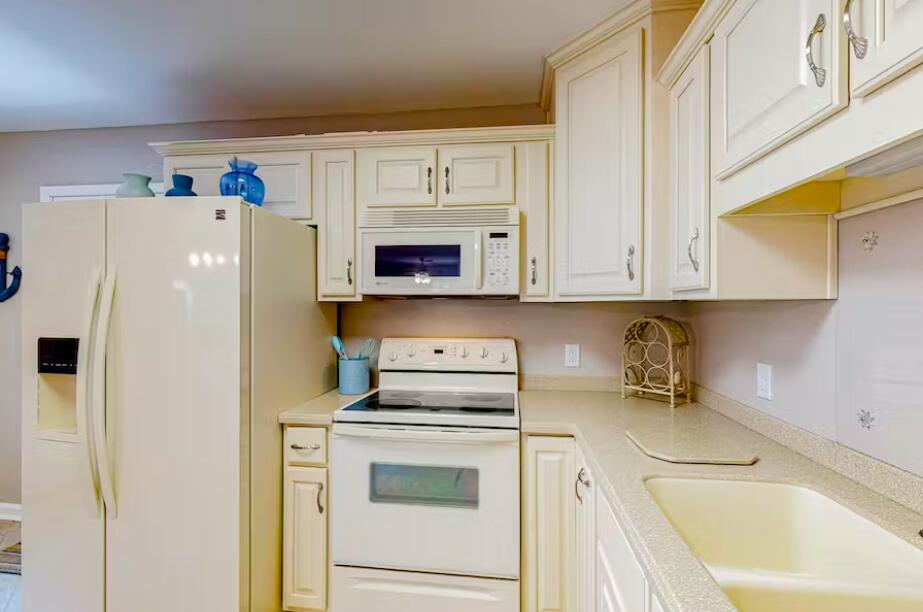 241 Ellis Road, Unit 8 Miramar Beach, FL 32550 - Photo 8 of 29 a white refrigerator freezer sitting inside of a kitchen