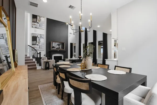 a kitchen with a refrigerator a sink dishwasher a dining table and chairs with wooden floor