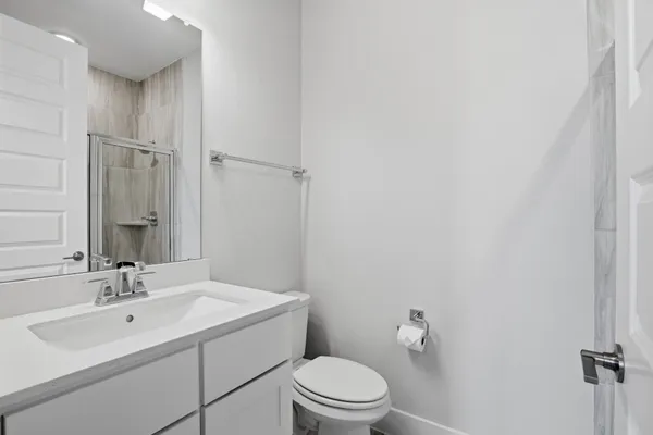 a bathroom with a sink toilet and a mirror