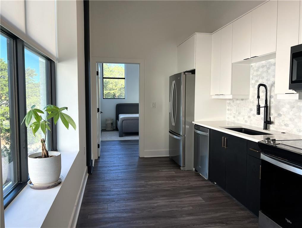 108 Park Place, Unit 311 Decatur, GA 30030 - Photo 7 of 23 a kitchen with stainless steel appliances a sink refrigerator and wooden floor