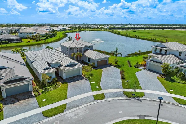an aerial view of a house with a garden and lake view