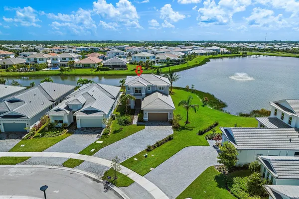 an aerial view of a house with a garden and lake view