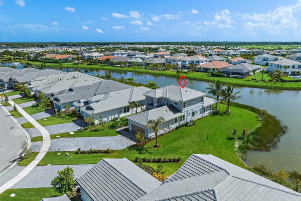 a front view of a house with a yard and potted plants