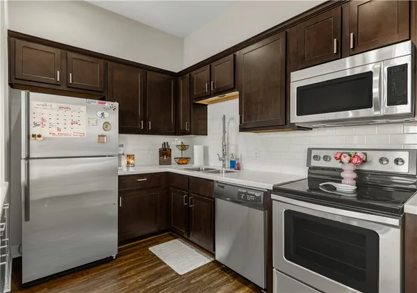a kitchen with stainless steel appliances a stove microwave and sink
