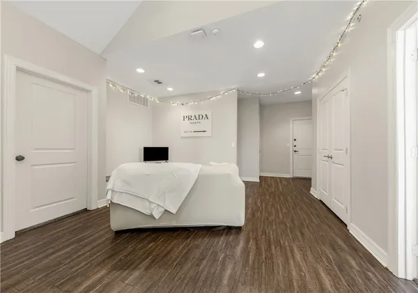 a spacious bedroom with a bed and a wooden floor