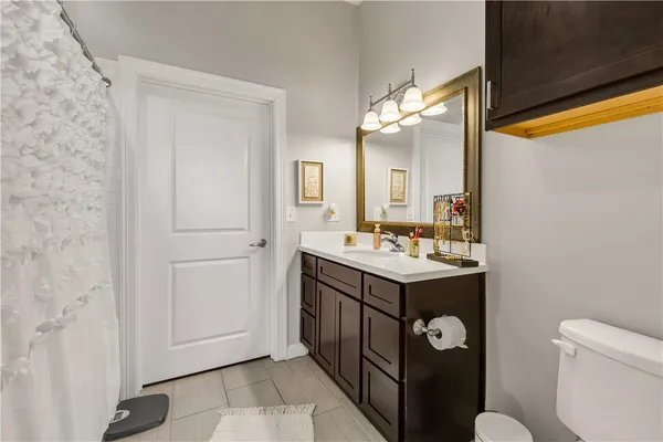 a bathroom with a sink a toilet and a mirror