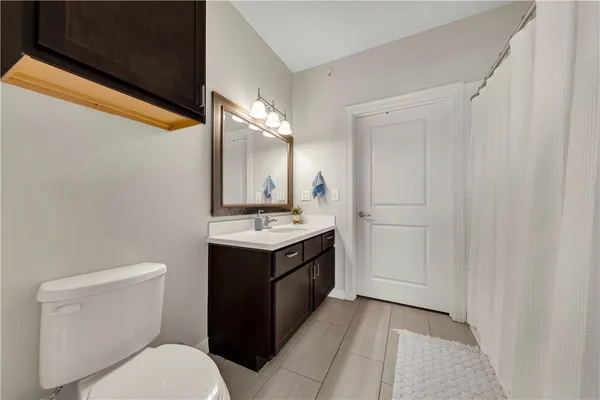 a bathroom with a toilet a sink and mirror